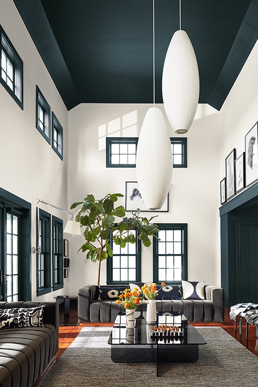 A dramatic living room with double height ceiling. The ceiling and window architraves are painted in Regent Green 2136-20 and the walls are painted in White Dove OC-17