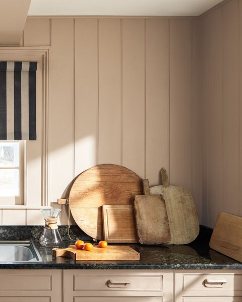 A kitchen with tongue and groove panelled walls, woodwork and cabinets painted in Sherwood Tan 1054.