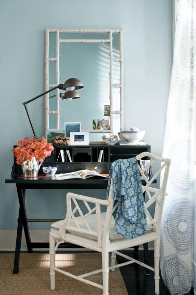 An airy study painted in A Breath of Fresh Air 806. Styling includes a black writing desk, a white chair and mirror plus reading lamp